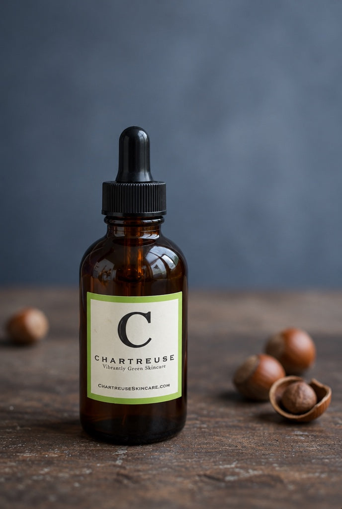 Body Oil in an amber dropper bottle with whole hazelnuts